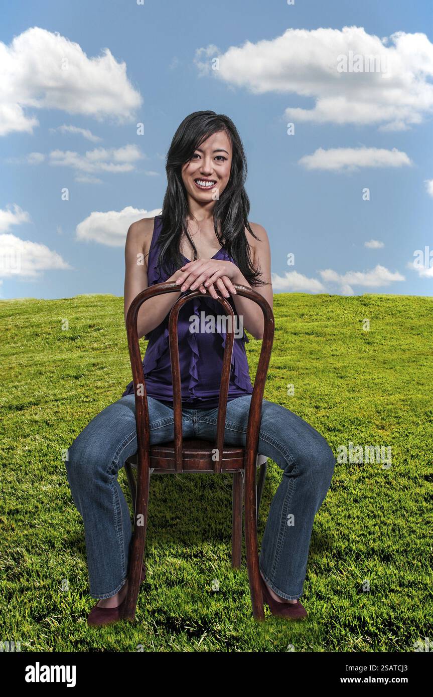Beautiful young Asian woman sitting in a chair Stock Photo - Alamy