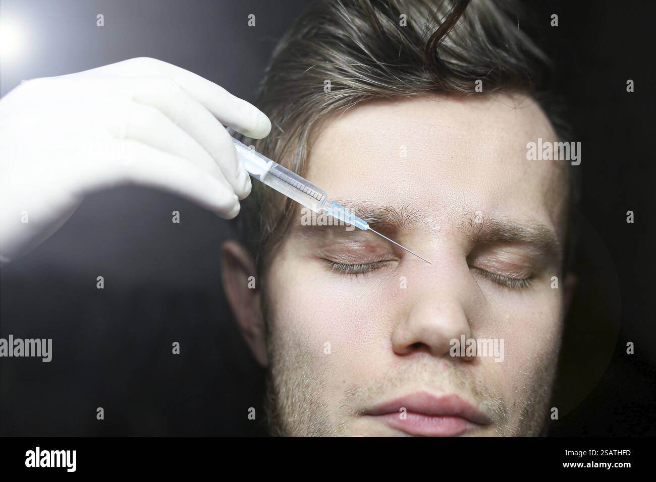 Close-up shows a syringe near a resting man with closed eyes ...