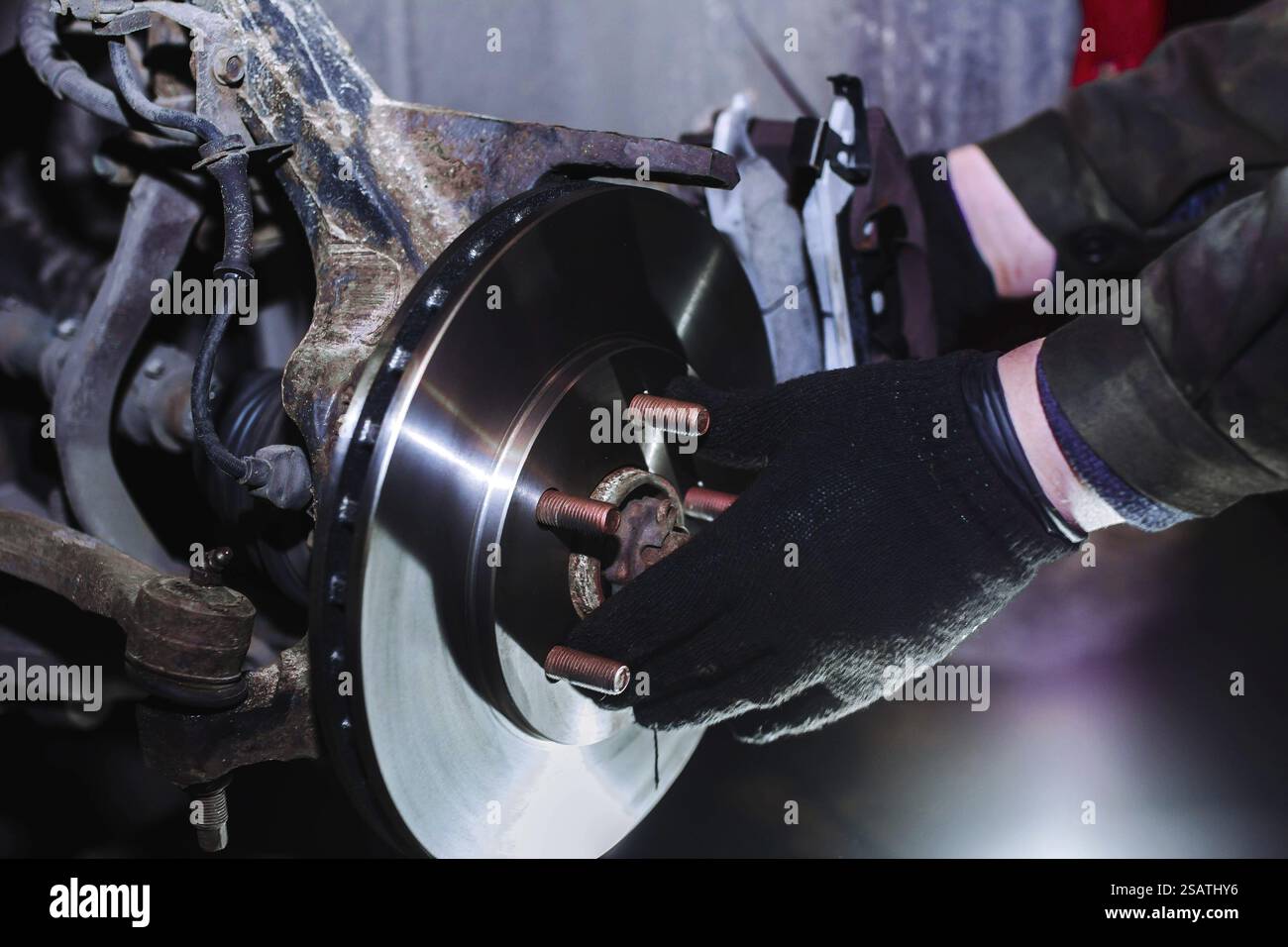 Mechanic working on brake assembly using gloves and tools Stock Photo ...
