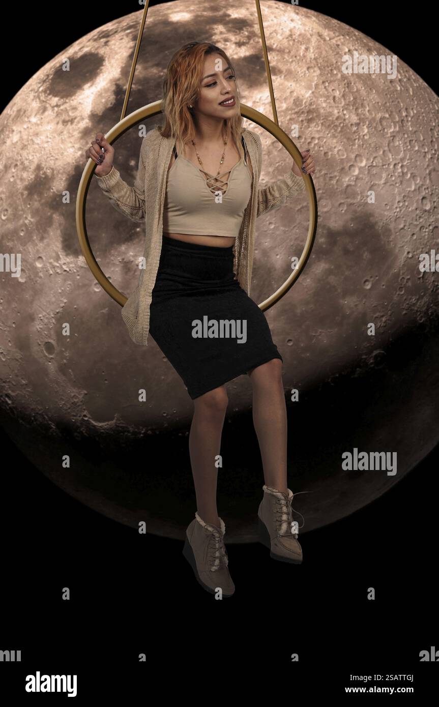 Woman swinging on a ring high up in the air Stock Photo - Alamy