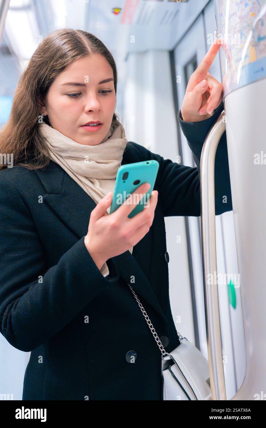 Young Woman Checking Subway Map While Using Smartphone.Vertical Stock Photo