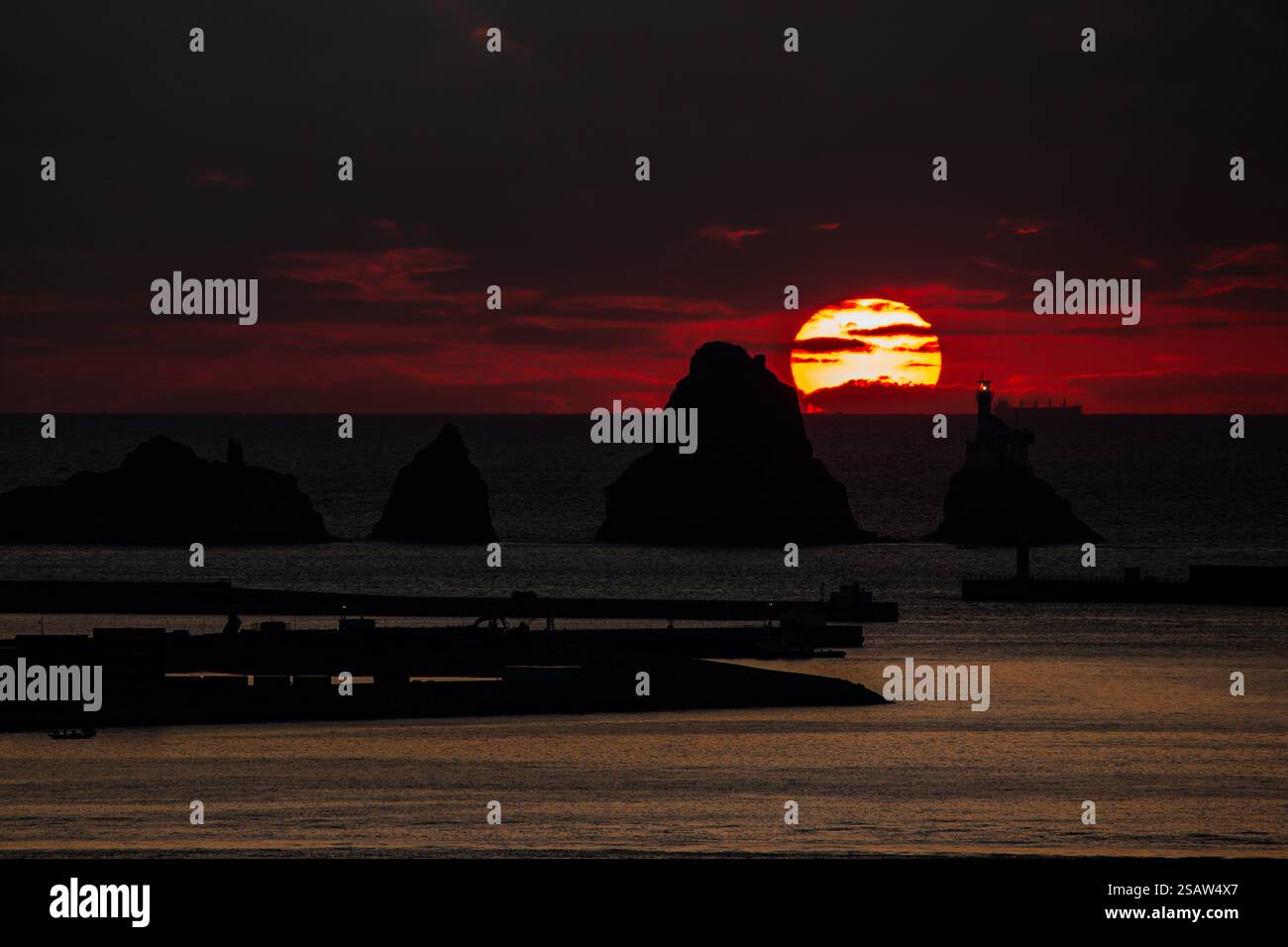 a huge sun rising behind the islands Stock Photo - Alamy
