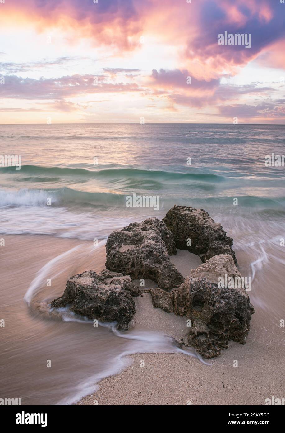 sunset on the beach with long exposure on rocks Stock Photo - Alamy