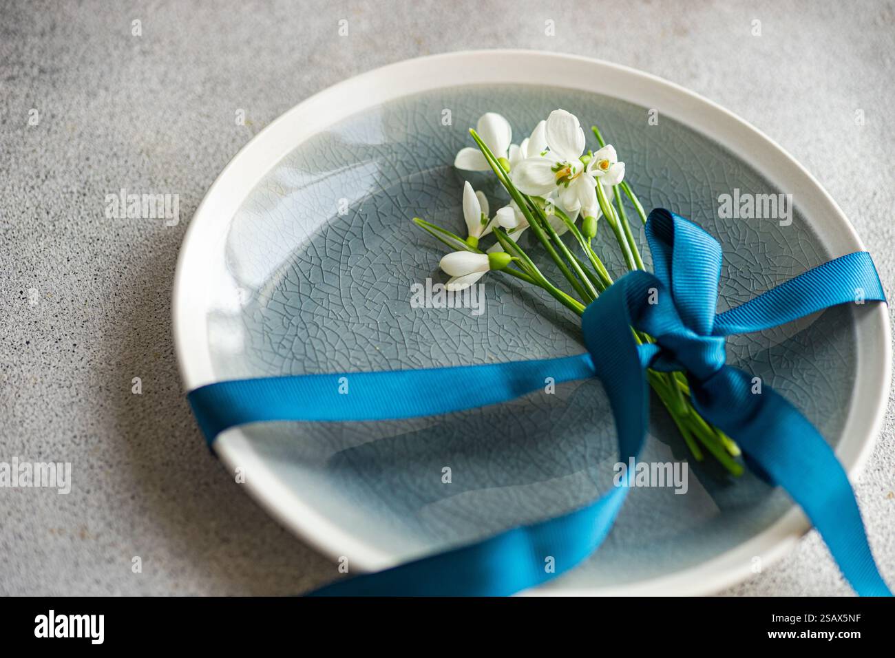 Table setting with snowdrops and ribbon Stock Photo