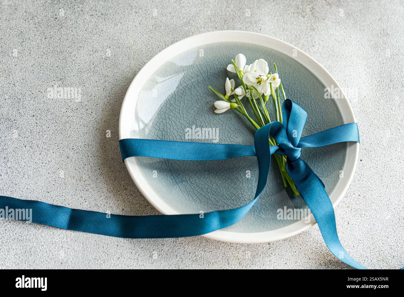 Table setting with snowdrops and ribbon Stock Photo