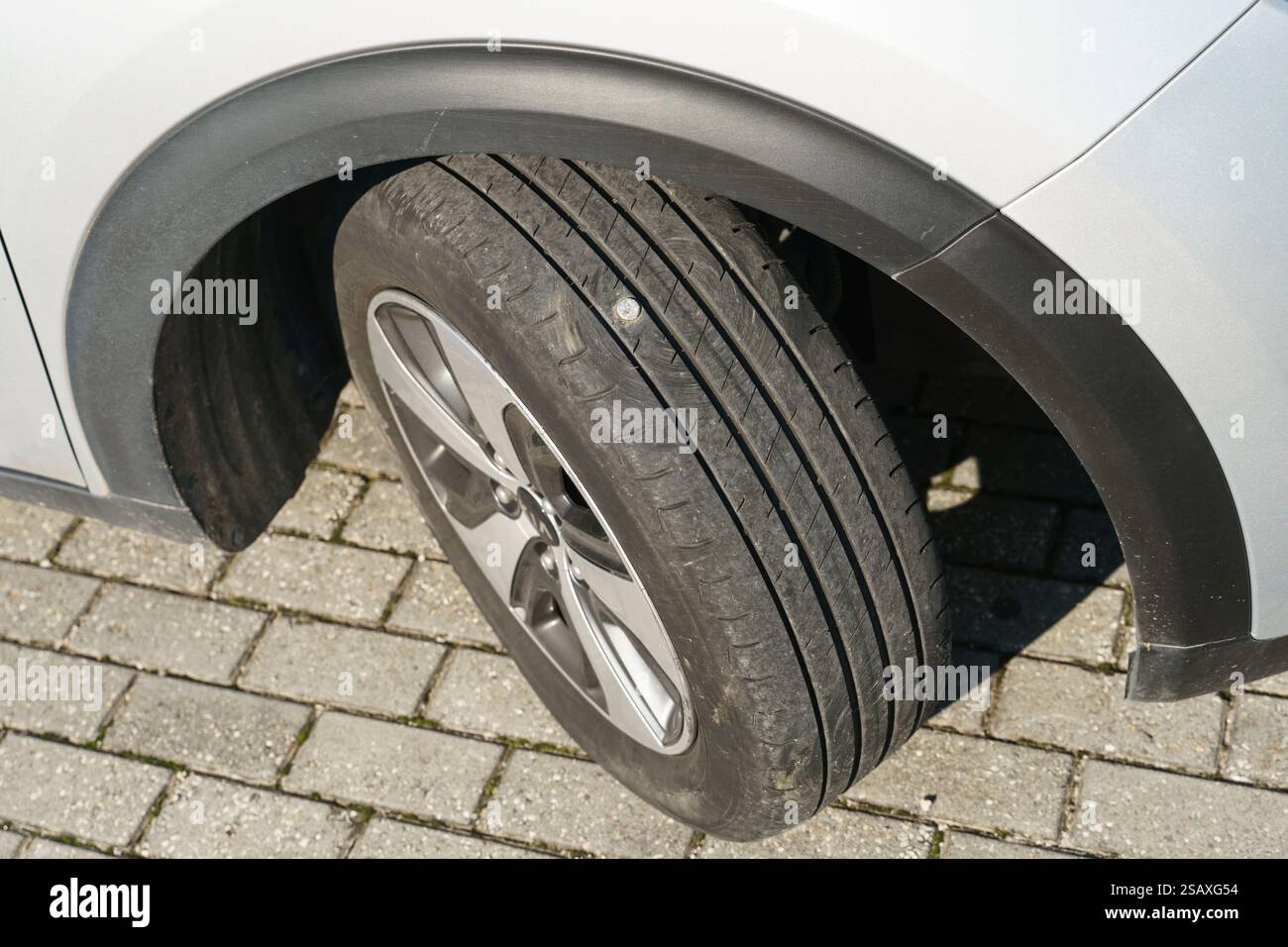 Car tyre punctured by a metal nail Stock Photo
