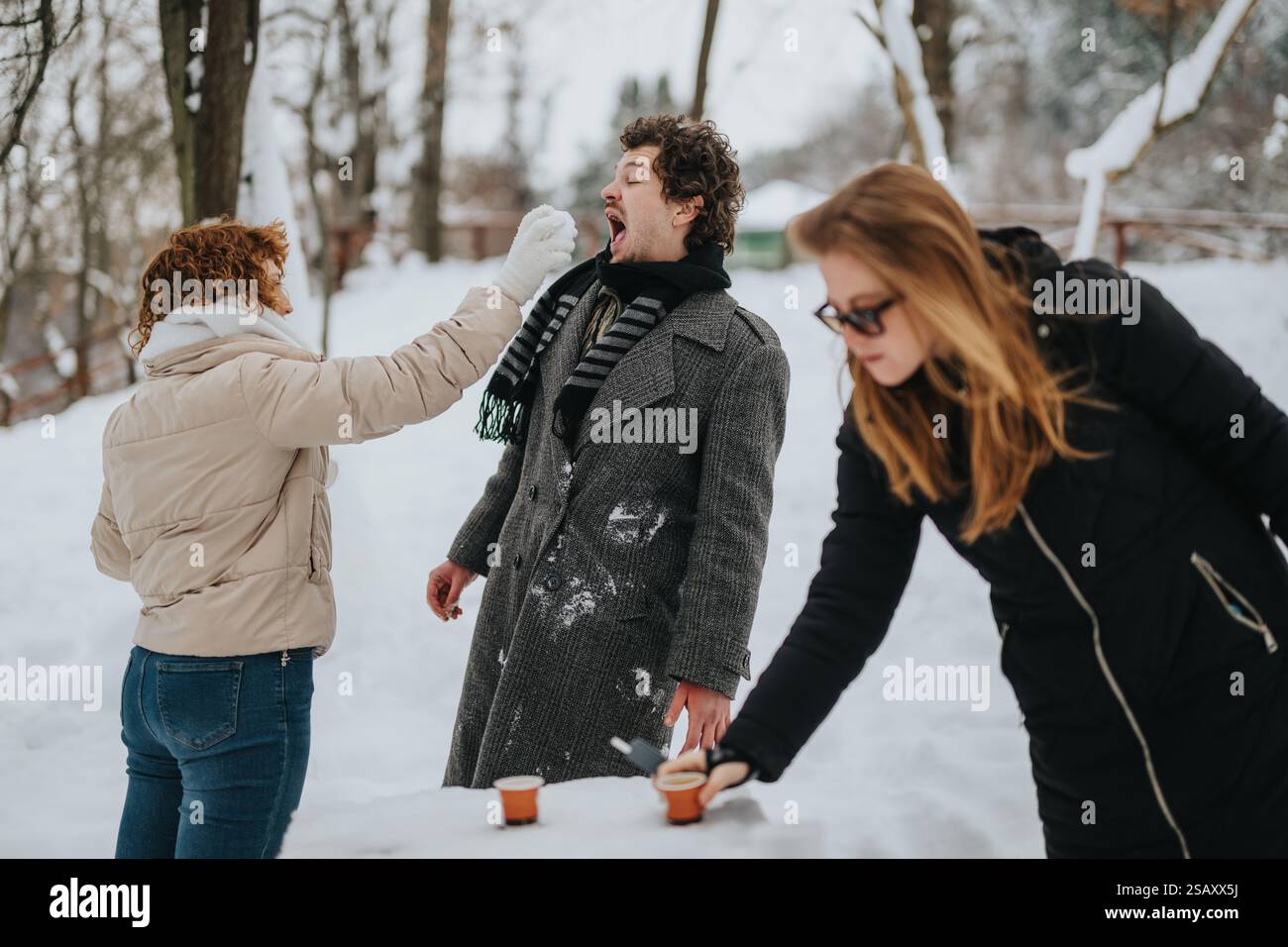 Friends enjoying a playful snow day in a scenic winter setting Stock ...