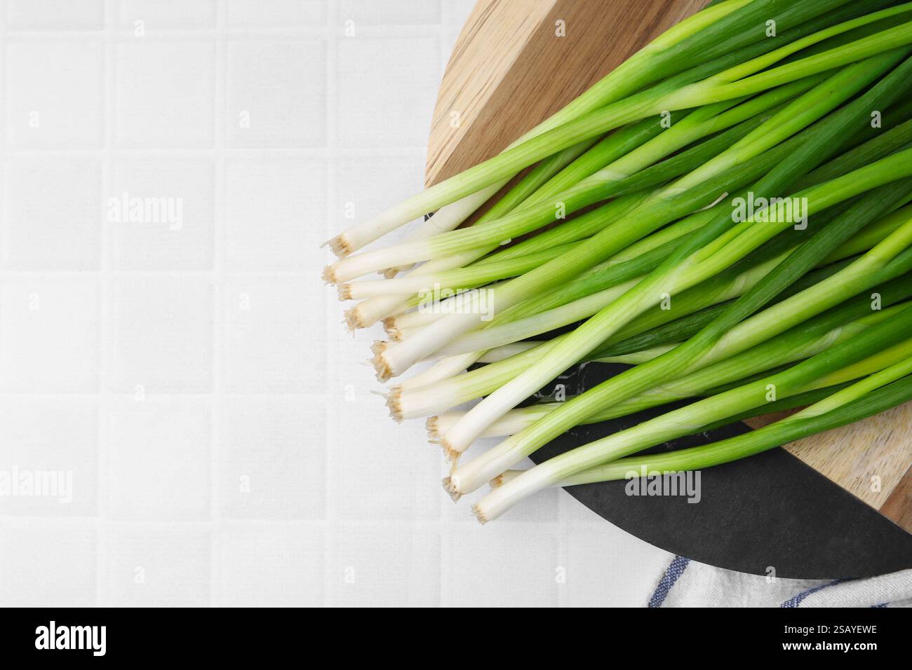 Fresh green onions on white tiled table, top view. Space for text Stock ...