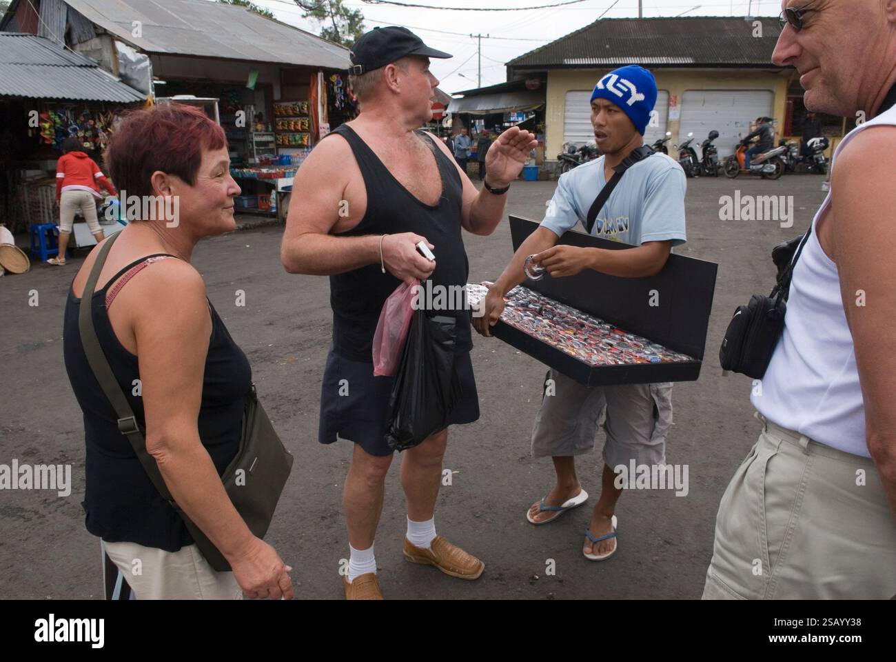 A man selling ccounterfeit fake Rolex watches and other designer brand in a street market to German tourists. Branded watches street market Ubud, Island of Bali in Indonesia Southeast Asia  2006 2000s HOMER SYKES Stock Photo