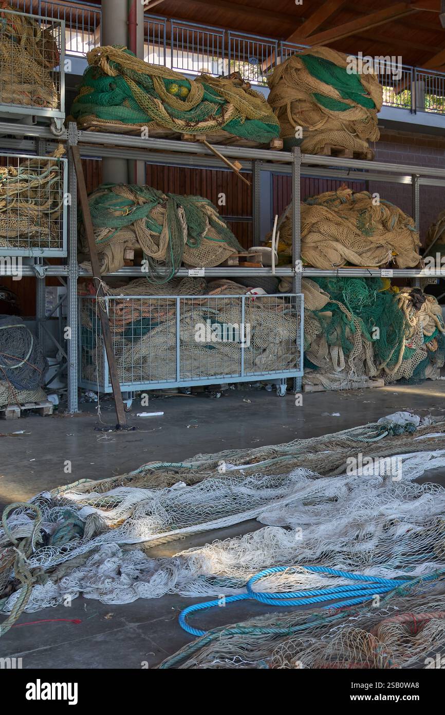 A large covered space with stacked fishing nets organized on metal ...