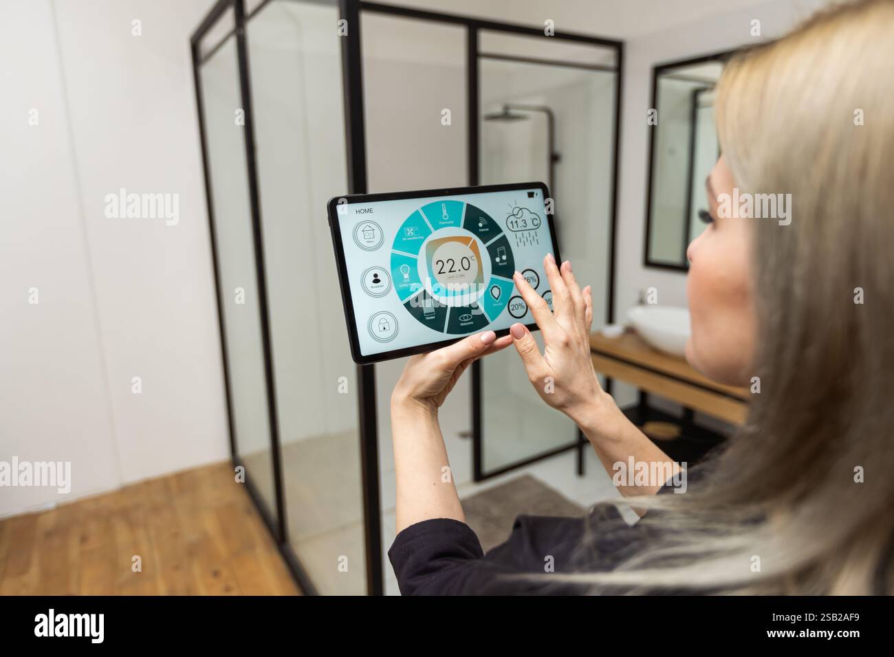 Digital composite of Hands using smart home application on tablet PC Stock Photo