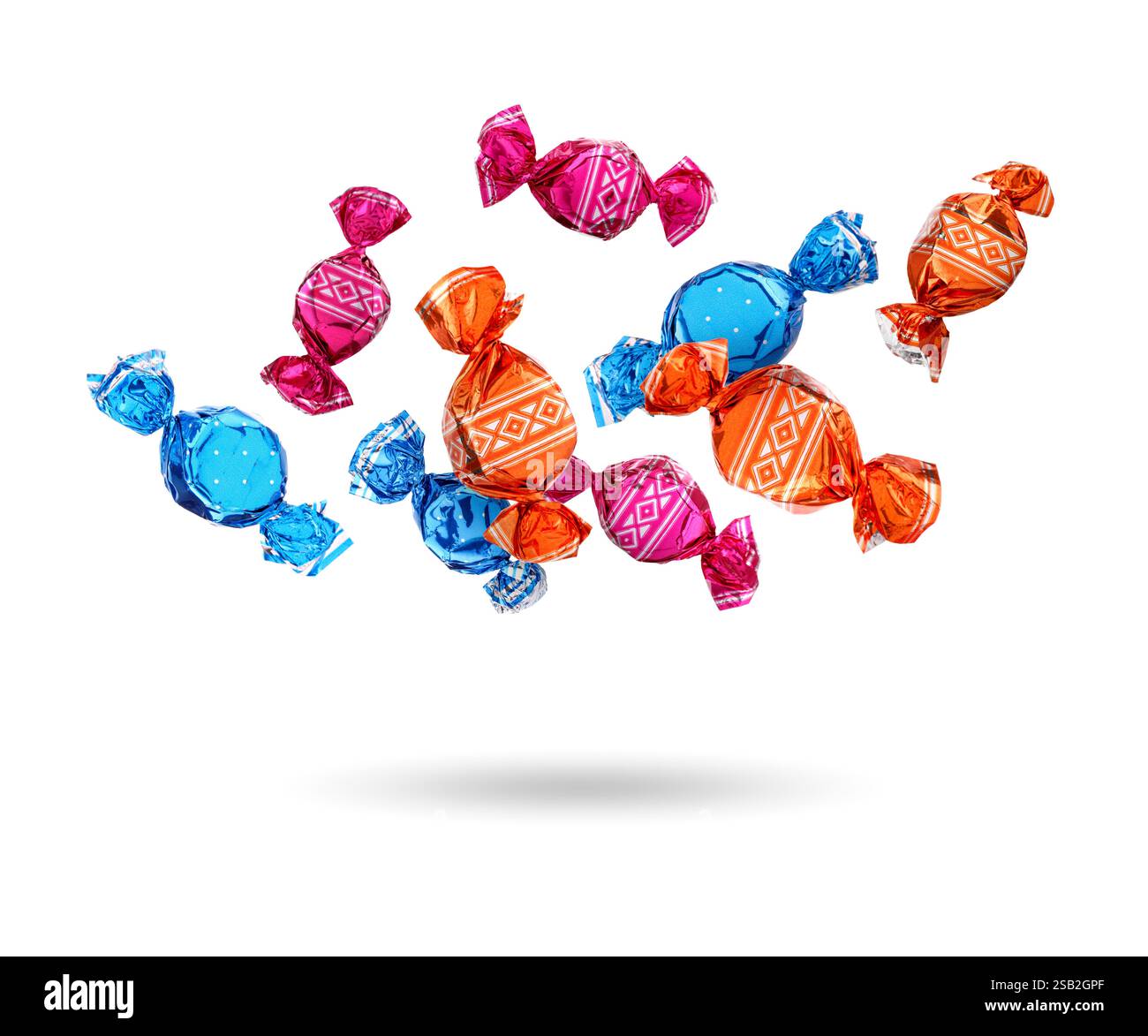 Candies in bright wrappers falling on white background Stock Photo