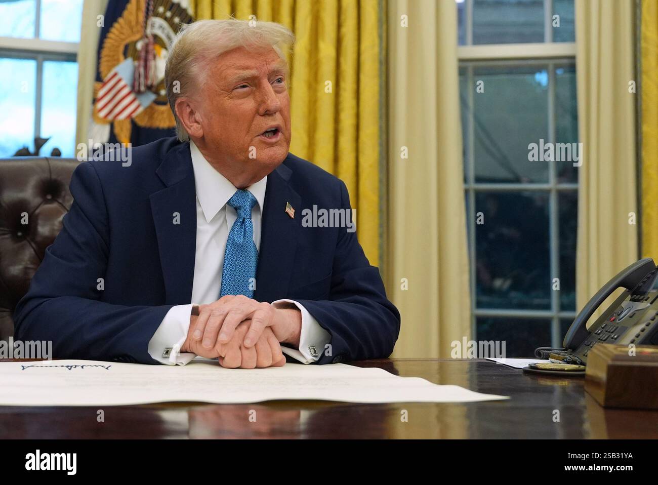 President Donald Trump speaks to reporters as he signs executive orders