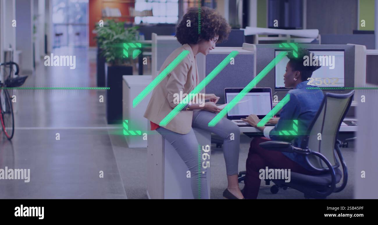 Discussing project over computer, colleagues in office with digital image overlay Stock Photo