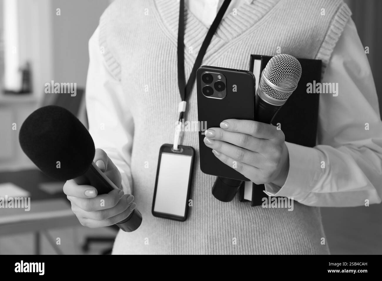 Journalist with microphones, mobile phone and notebook, closeup. Toned in black-and-white Stock Photo