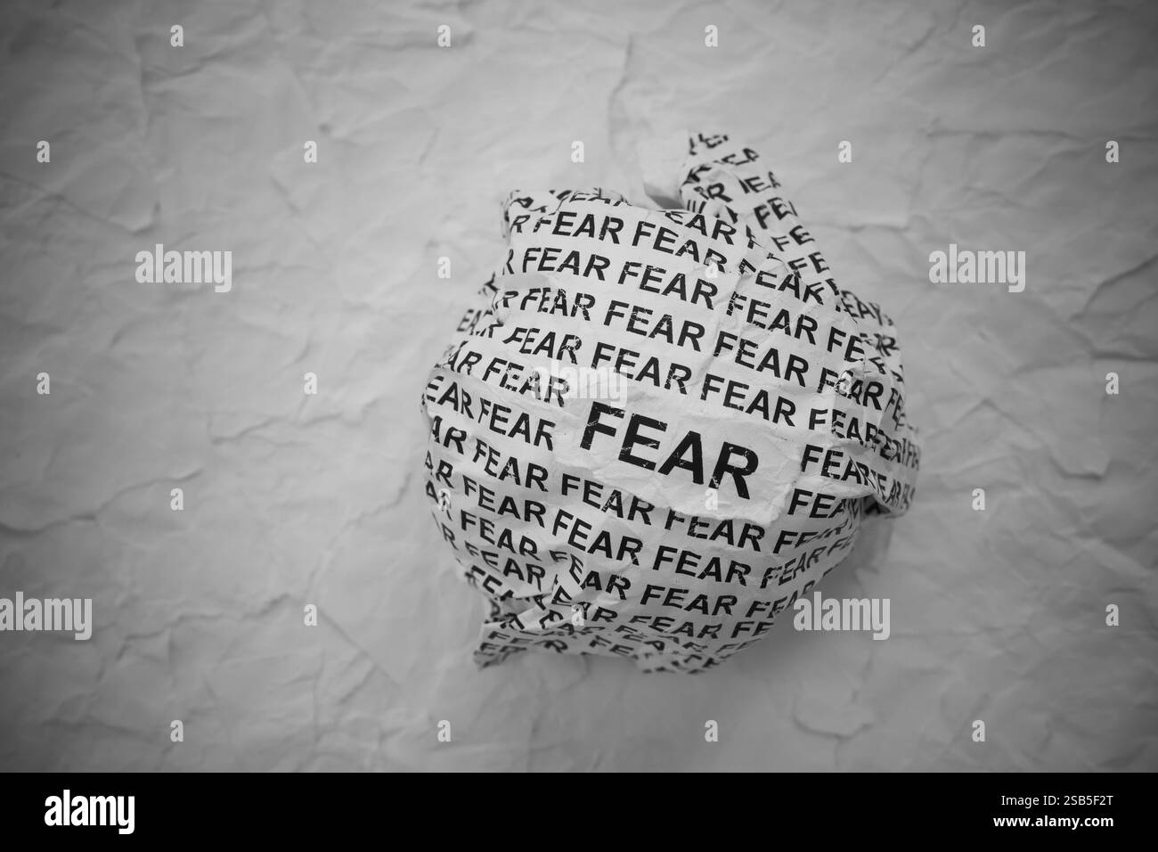 Crumpled paper ball with words Fear on torn white paper pieces ...