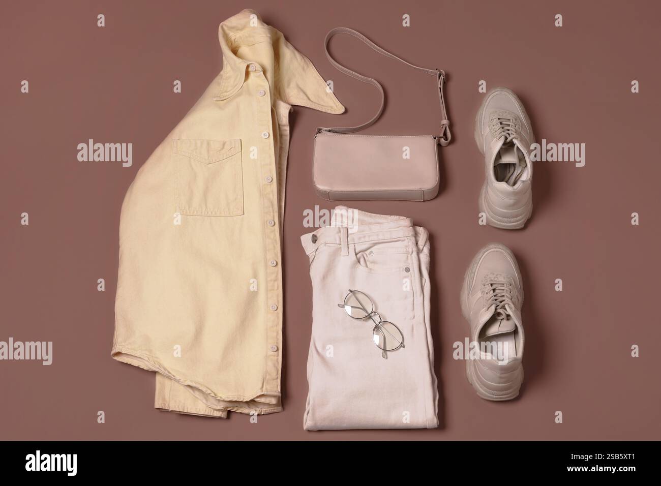 Stylish outfit with bag on mocha mousse shade background, flat lay ...
