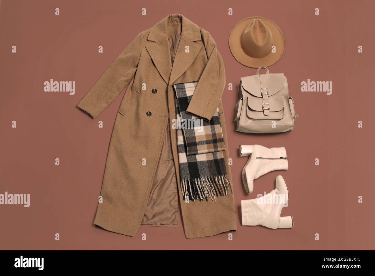 Stylish outfit with backpack in mocha mousse shade on brown background ...