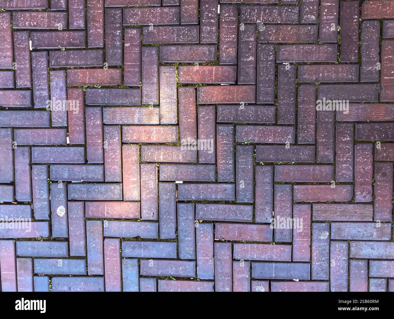 Brick wall with a zigzag pattern. The bricks are brown and the pattern ...