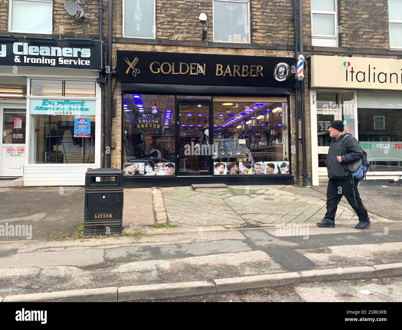 Leeds Yorkshire England UK shop shops town street people walk walking town life barbers restaurant cleaners Italian food barbers man with hat on walk - Smartphone Captured Stock Image
