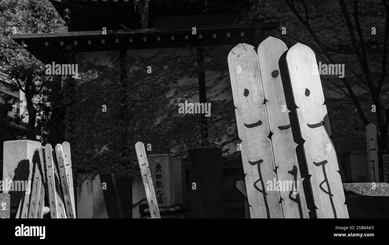 Wooden grave tablets with a vertical Sanskrit inscription are placed behind or against family gravestones at most Buddhist cemeteries in Japan. The la Stock Photo