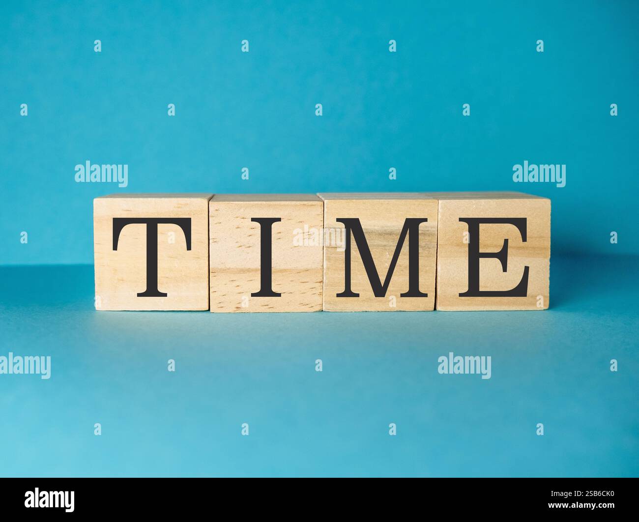The word time is written in wooden blocks on a blue background. The ...