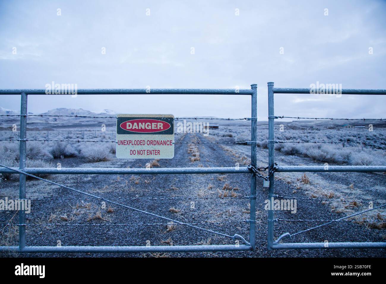 A locked gate marks the entrance to the Sierra Army Depot near Herlong, CA, warning of dangers from unexploded ordnance Stock Photo