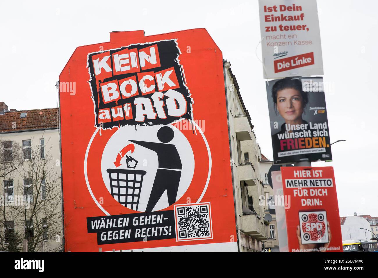 Kein Bock auf AfD , Wandbild in Neukölln, Berlin, 01.02.2025 Kein Bock auf AfD / Wählen gehen - gegen rechts lautet der Text eines überdimensionalen Wandbilds auf einer Hauswand an der Karl-Marx-Straße in Berlin Neukölln. Angefertigt wurde das Bild wurde von der seit 2016 bestehenden Initiative Kein Bock auf Nazis . Im Vordergrund hängen Wahlplakate der Parteien Die Linke  Ist Dein Einkauf zu teuer, macht ein Konzern Kasse , BSW  Unser Land wünscht sich Frieden.  und SPD  Hier ist mehr Netto für Dich drin.  an einem Laternenmast. Berlin, 01.02.2025 Berlin *** Kein Bock auf AfD , mural in Neukö Stock Photo