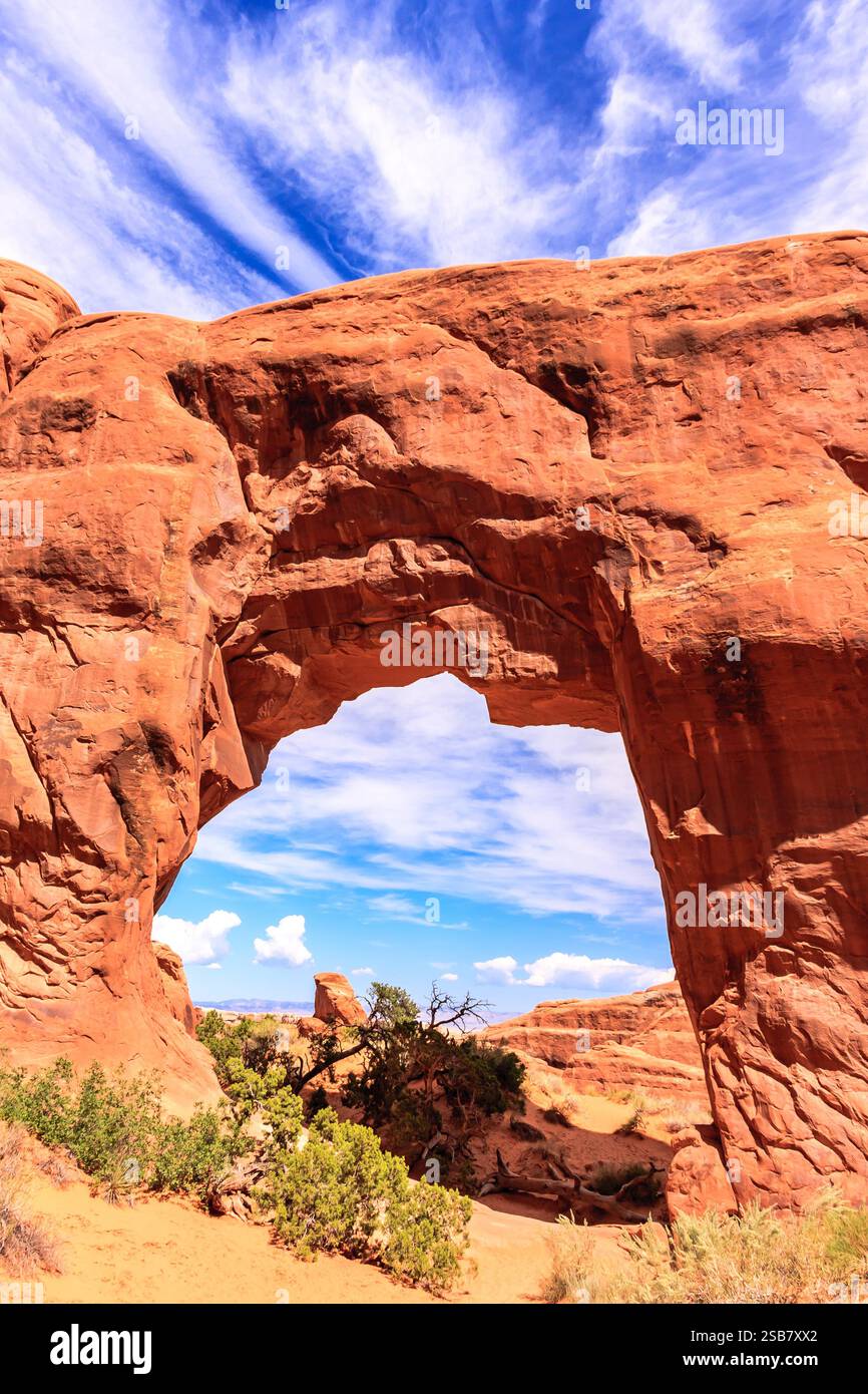 A large archway in a desert with a clear blue sky above. The archway is ...