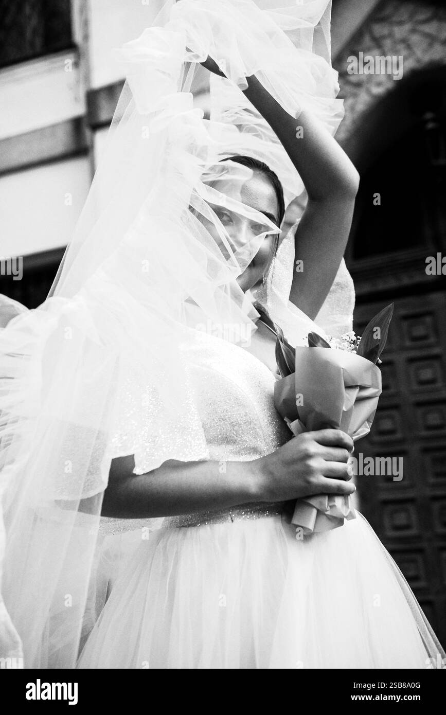 Bride in a white dress with a veil covering her face Stock Photo - Alamy
