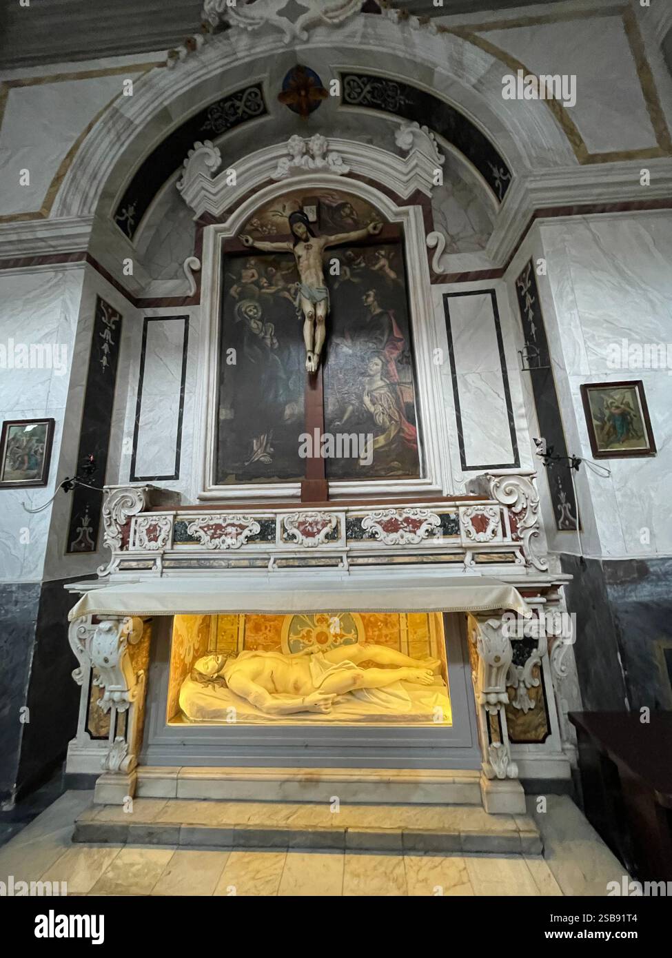 Noci, Italy. Interior of the medieval Church of Saint Mary and Saint Roch (Chiesa madre). The altar of the cross. Jesus Christ crucified and buried. - Smartphone Captured Stock Image