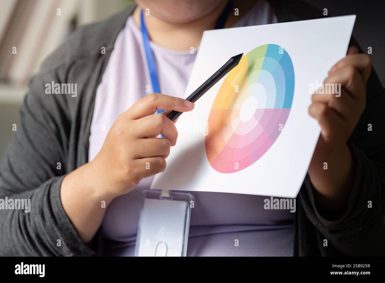 Graphic designer analyzing a color wheel for creative design projects Stock Photo