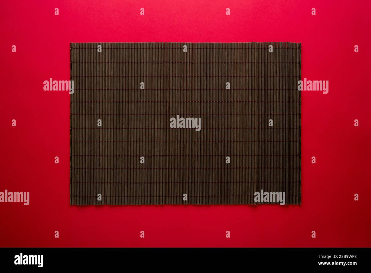 Empty bamboo mat on red background. Chinese food concept background Stock Photo