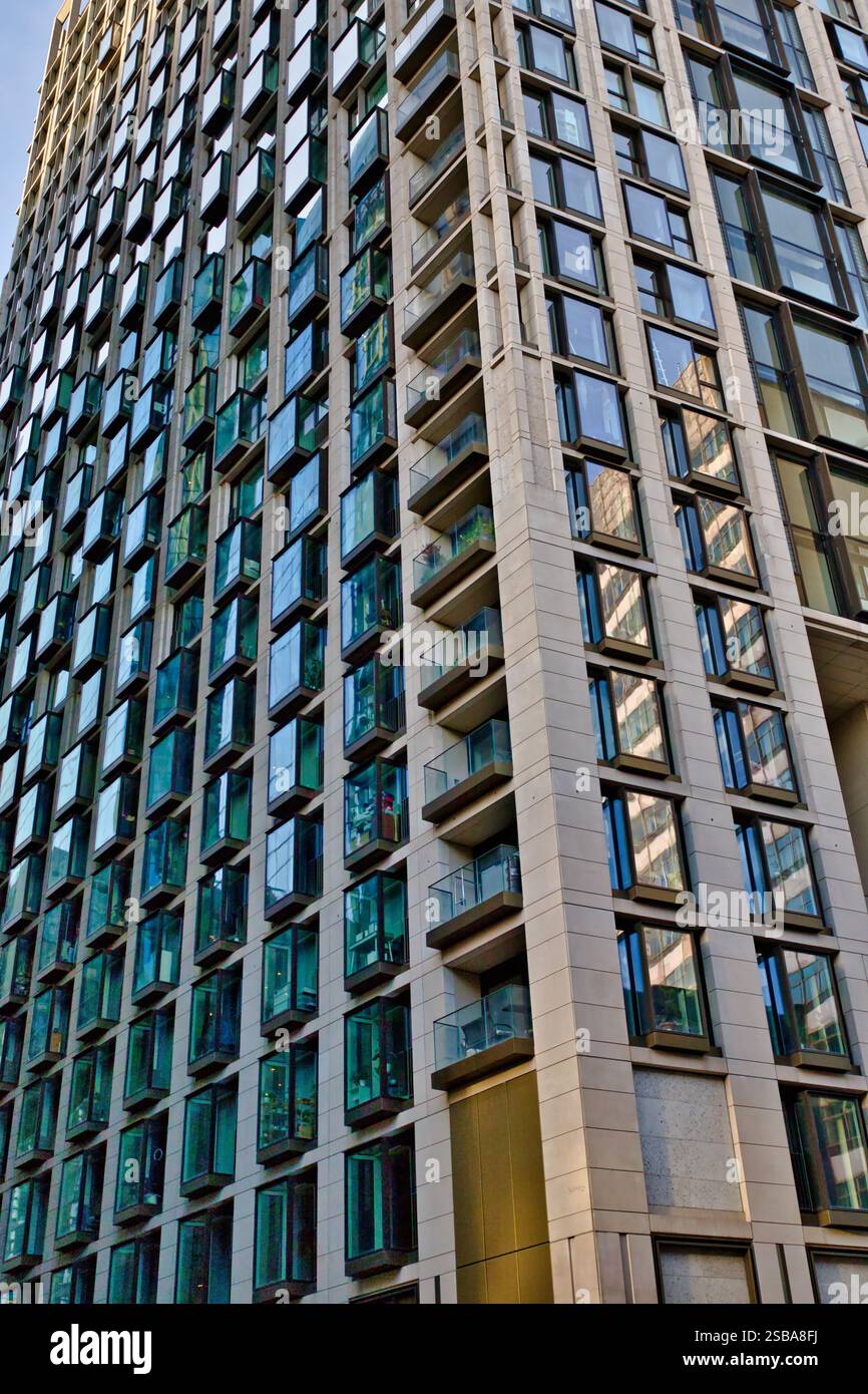 A high-rise residential building features numerous balconies and teal ...