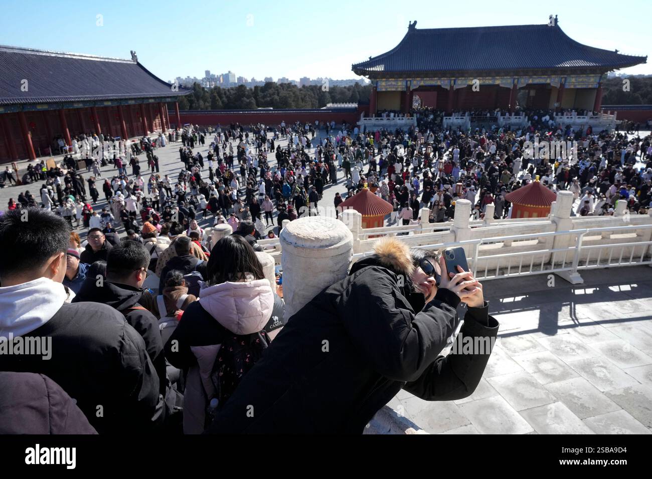 A woman takes pictures at the Temple of Heaven complex during a week