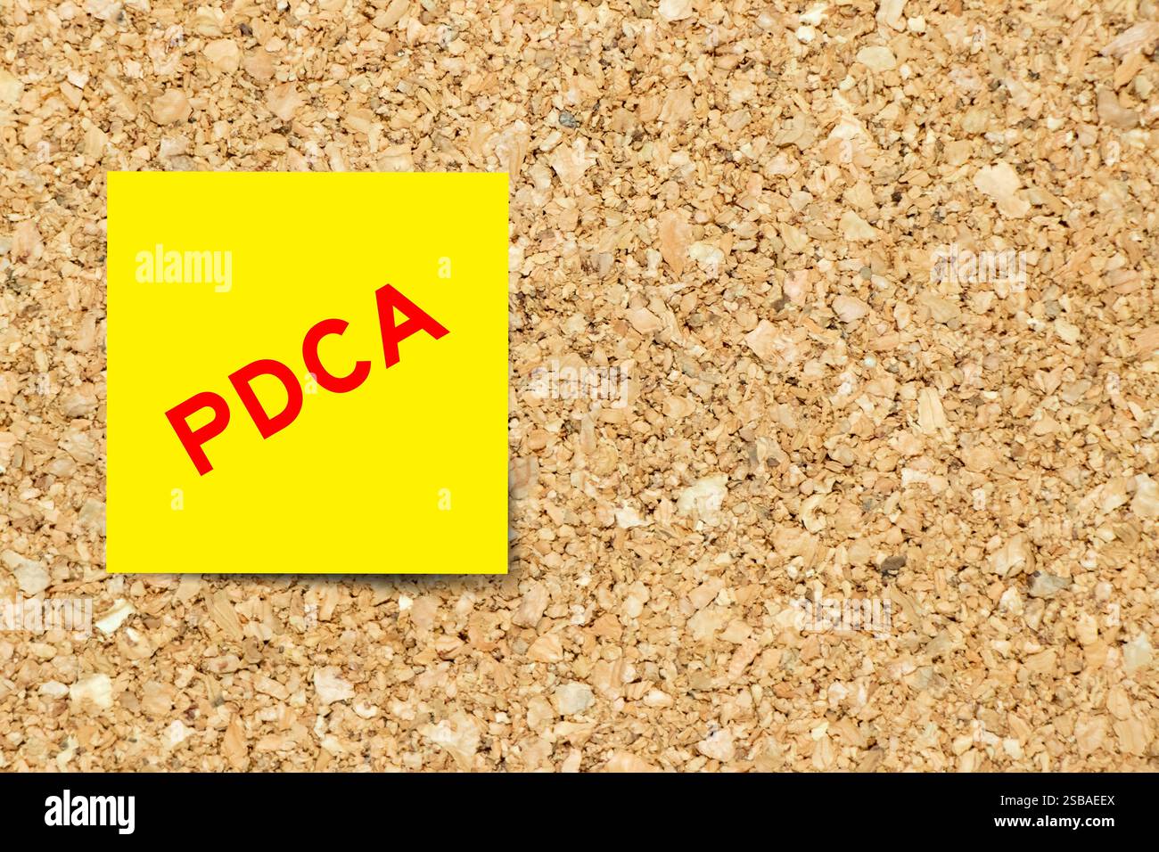 Yellow note paper with word PDCA (Abbreviation of plan do check act) on ...