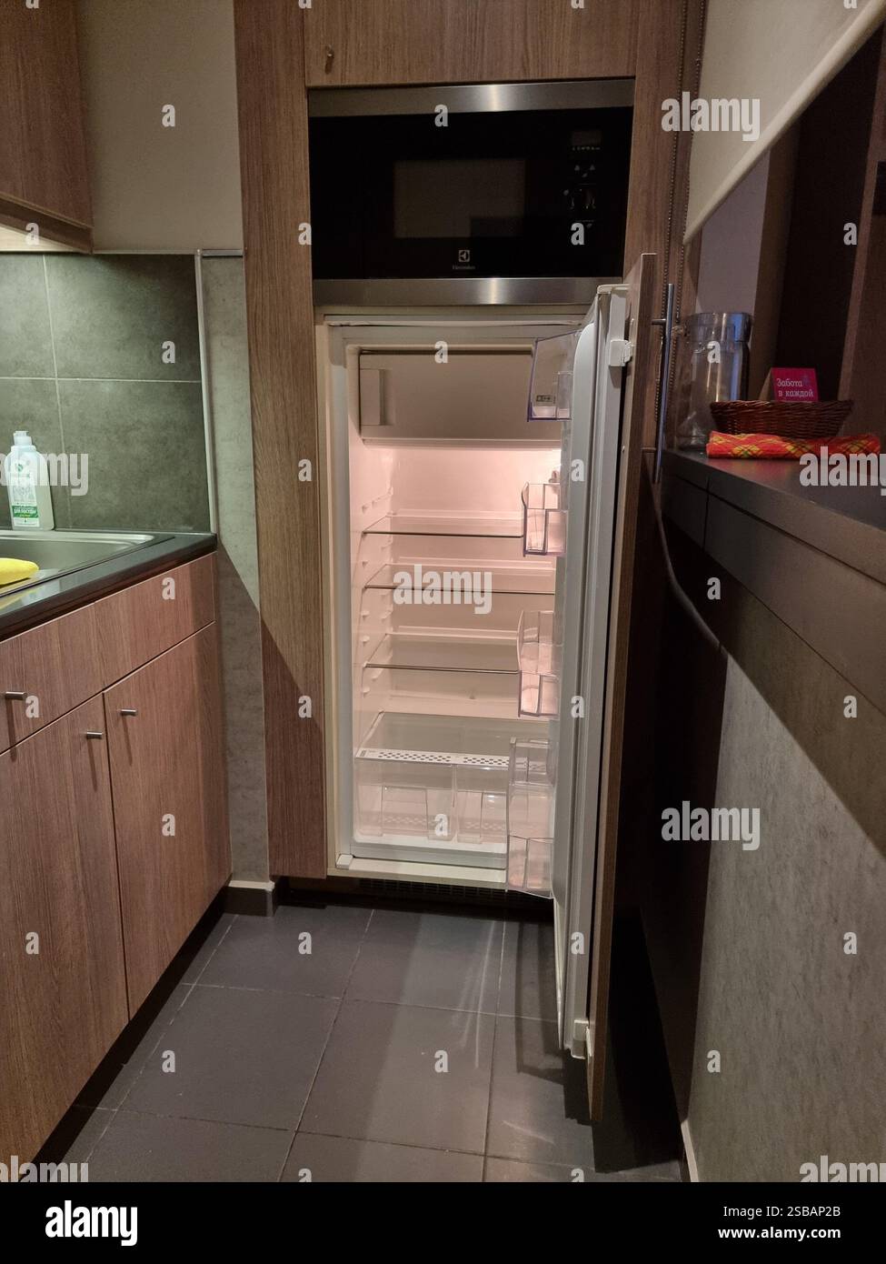 Empty refrigerator / fridge with open door; in a kitchen with microwave etc. - Smartphone Captured Stock Image