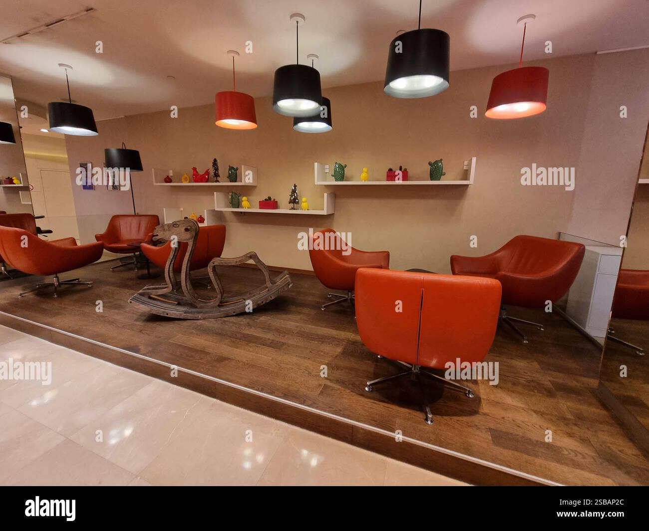 Leather design armchairs, pendant lamps and rocking horse chair in the lobby of an Adagio hotel - Smartphone Captured Stock Image Leather design armchairs, pendant lamps and rocking horse chair in the lobby of an Adagio hotel - Smartphone Captured Stock Image
