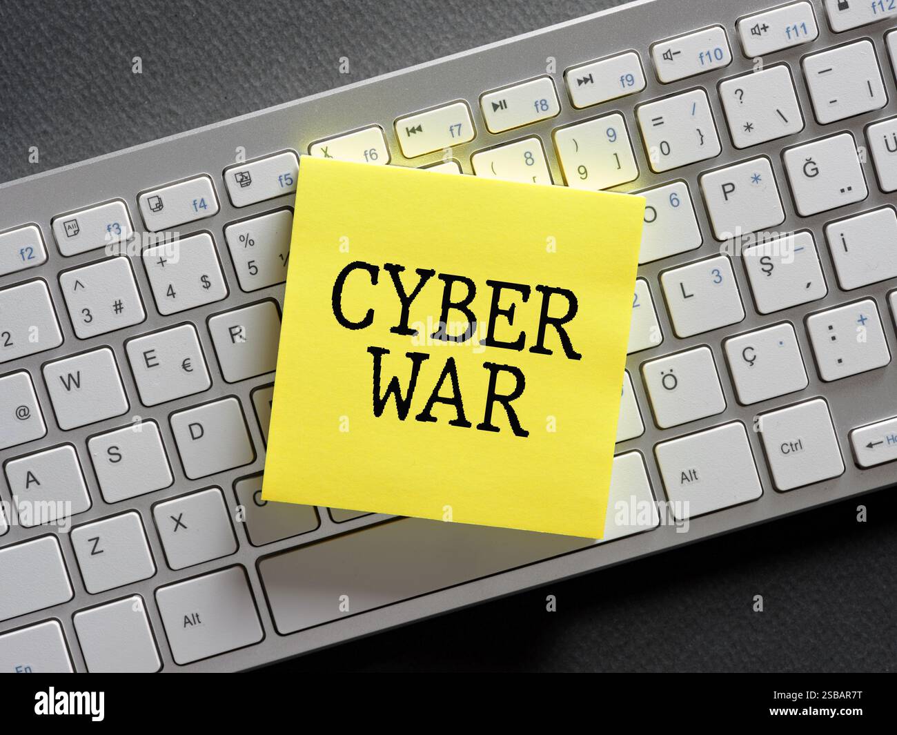 The word cyber war written on a sticky note paper on computer keyboard. Business concept for virtual war, hacker system attacks or digital theft. Stock Photo
