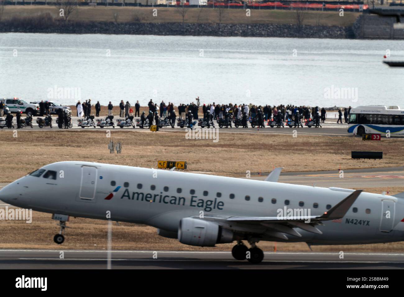 An American Eagle jet passes as families of the victims of a mid-air ...