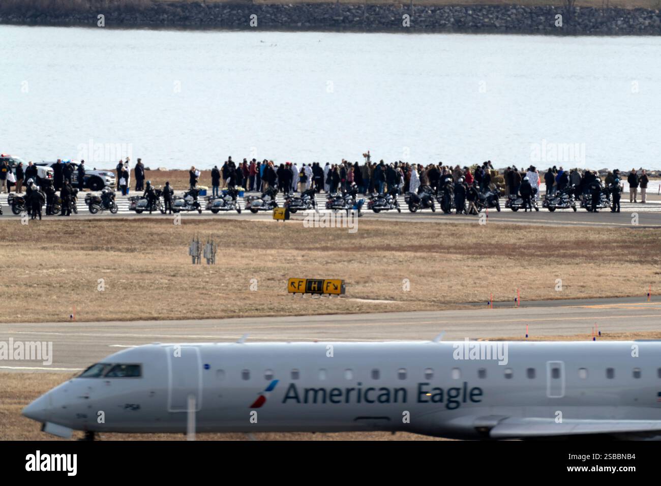 An American Eagle jet passes as families of the victims of a mid-air ...