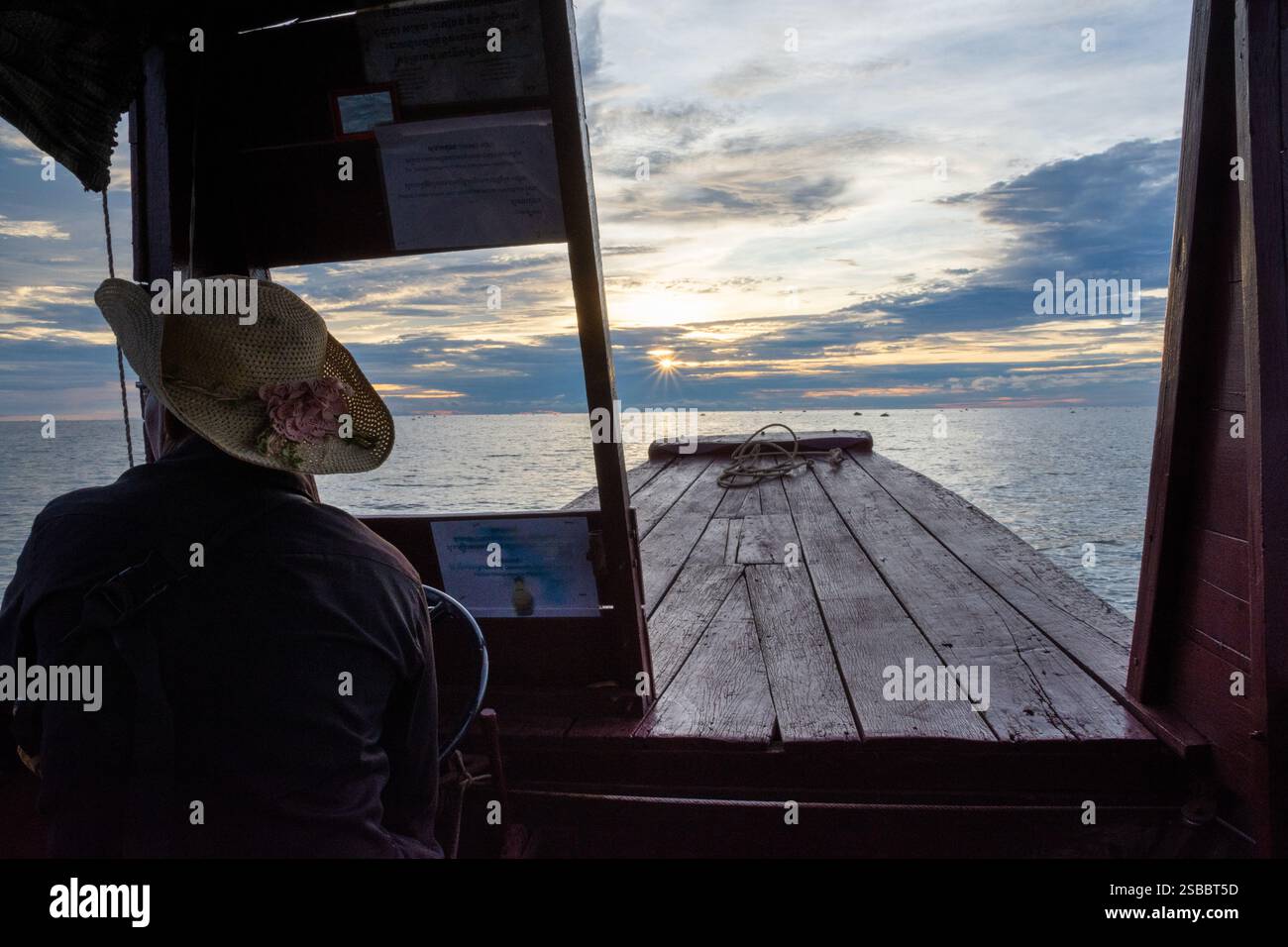 Kompong Khleang, Cambodia - 25 October 2023: Serene sunset view from a traditional wooden boat Stock Photo