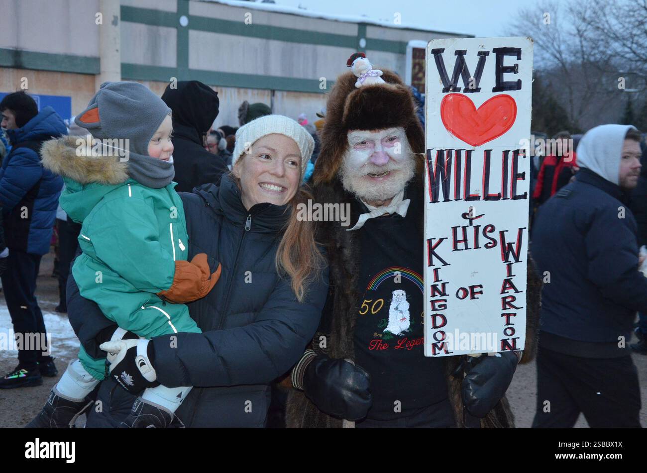 People holds signs during a Groundhog Day event in Wiarton, Ont. on