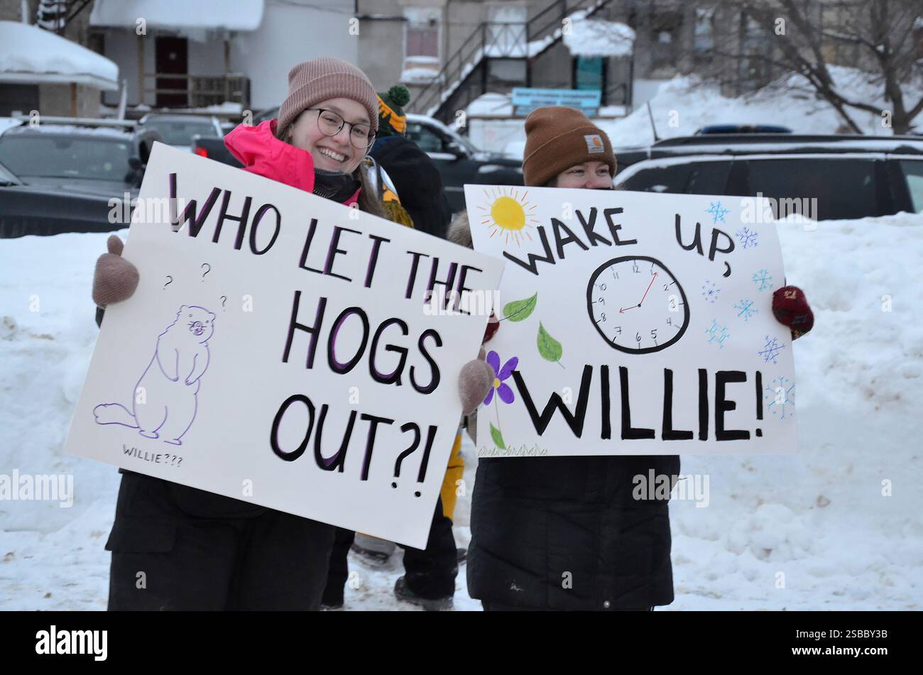 People holds signs during a Groundhog Day event in Wiarton, Ont. on