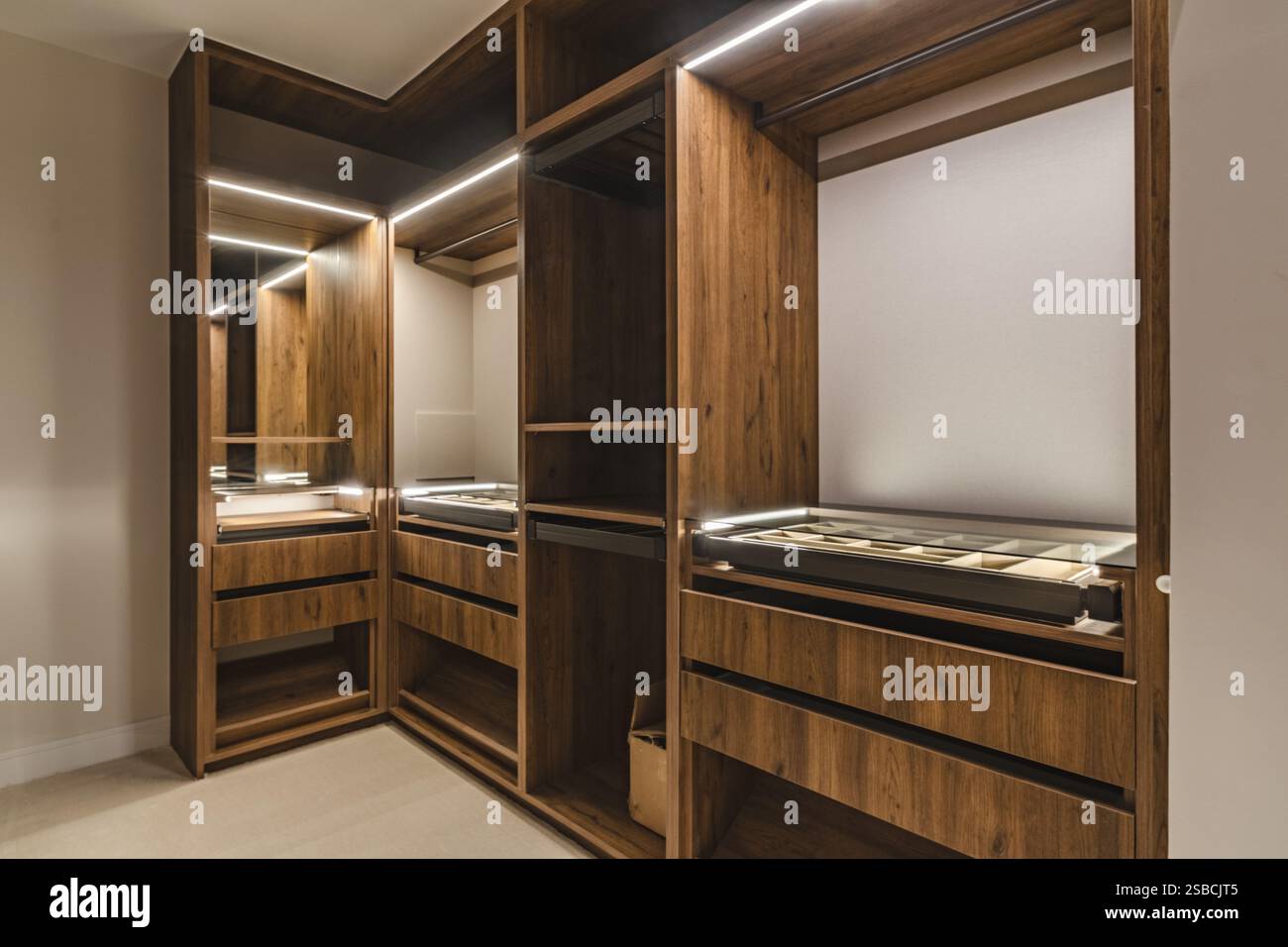 an image of an open illuminated walk in closet wardrobe in luxury mediterranean real estate Stock Photo