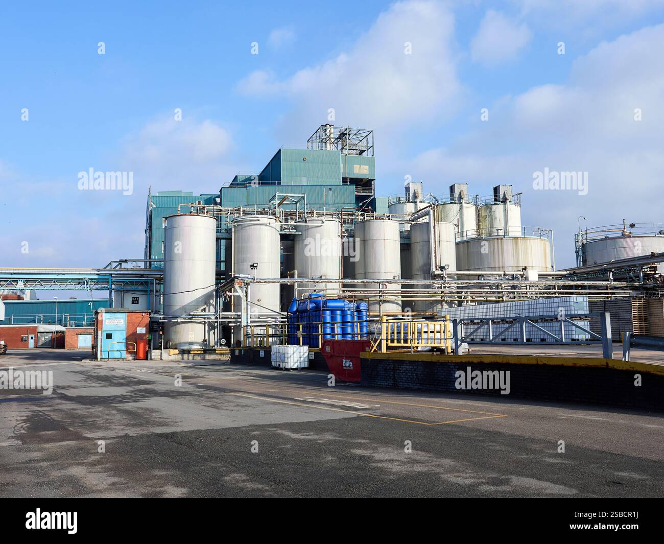 Industrial Chemical facility with large tanks under a partly cloudy sky ...