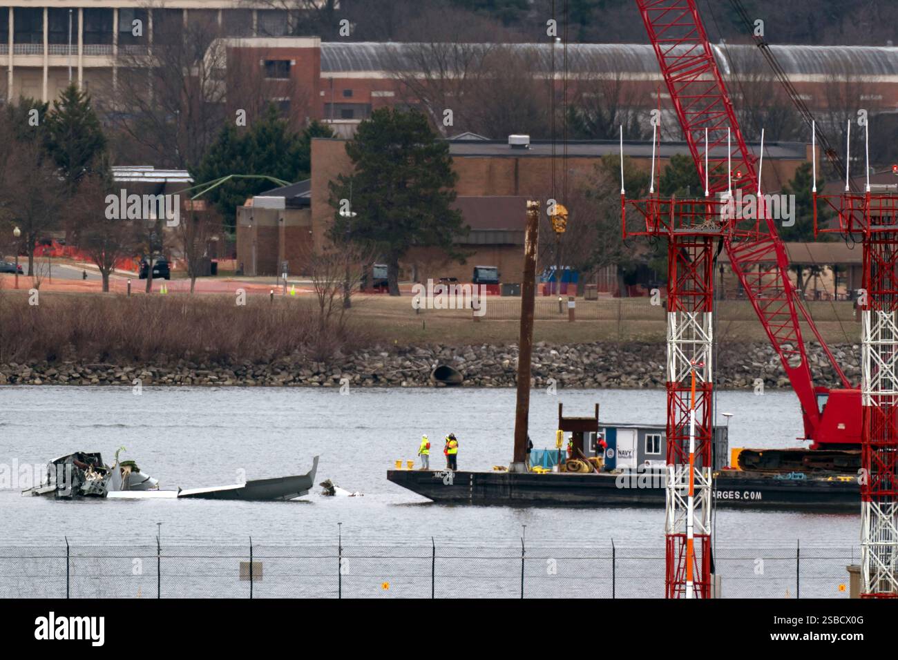 Rescue and salvage crews with cranes work near the wreckage of an ...