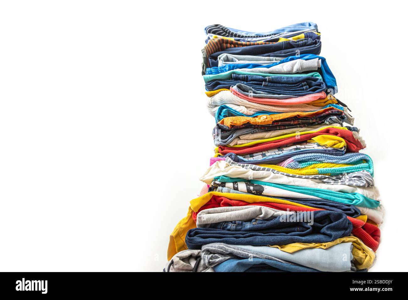 A very tall stack of folded colored clothes for charity, washing ...