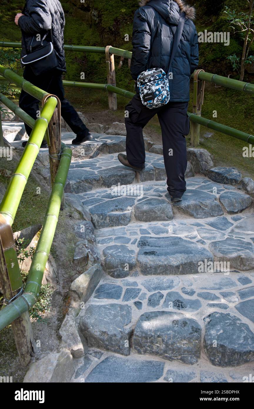 A couple walking along the landscape garden pathway at Ginkakuji Zen Buddhist temple in Kyoto, Japan. Stock Photo