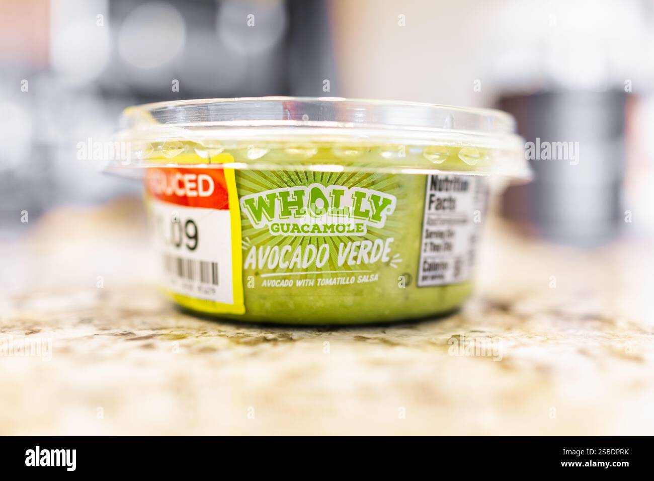 Avon, USA - October 21, 2022: Plastic container of green guacamole verde salsa flavor by Wholly brand with reduced price in Kroger store grocery Stock Photo